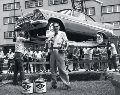 A man with scary looking glasses shows off what he's loading - cans of oil?
